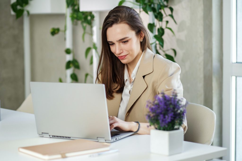 Woman is working job on laptop computer in modern office. Concept of work, study and it.